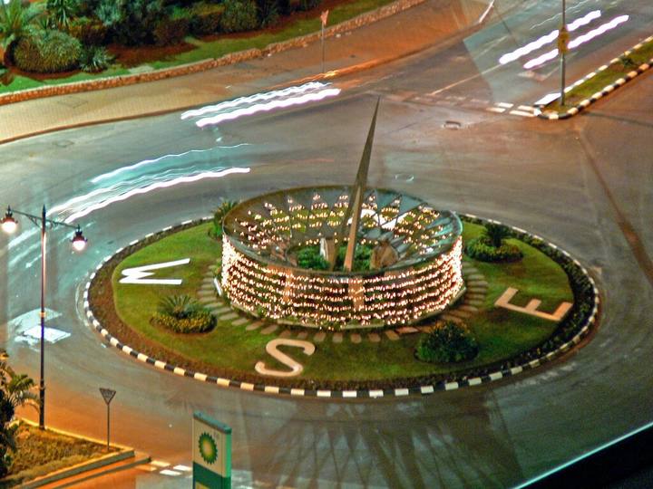 The planted Sundial Roundabout at night, seen from above, with the light trails of traffic circling it.